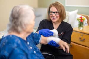 Nurse wrapping bandage on patient's arm